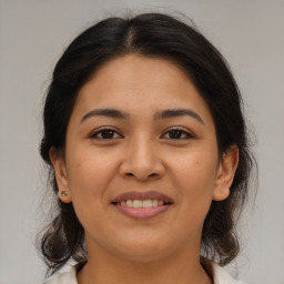 Joyful latino young-adult female with medium  brown hair and brown eyes