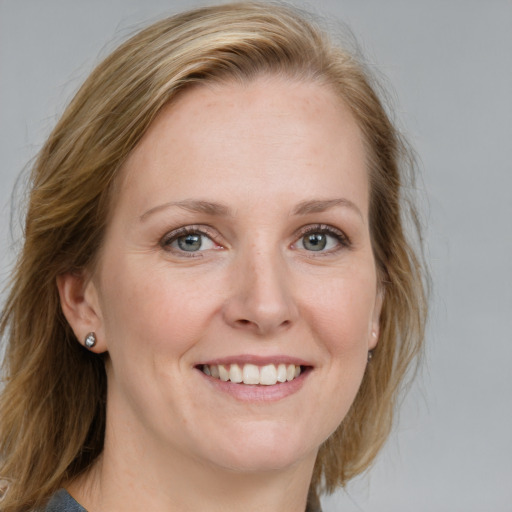 Joyful white adult female with medium  brown hair and blue eyes