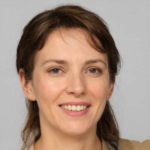 Joyful white young-adult female with medium  brown hair and grey eyes