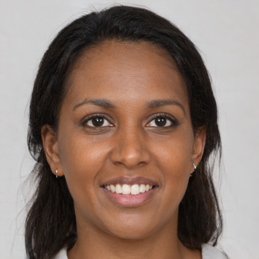Joyful black young-adult female with medium  brown hair and brown eyes
