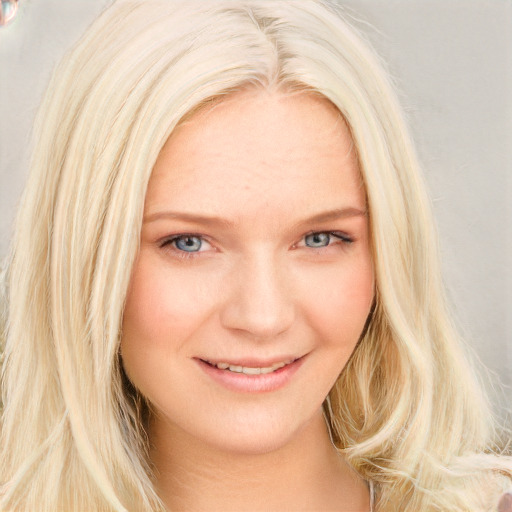 Joyful white young-adult female with long  blond hair and blue eyes