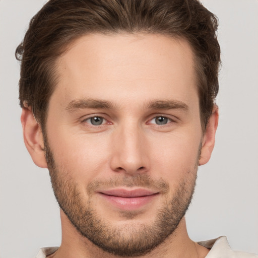 Joyful white young-adult male with short  brown hair and grey eyes