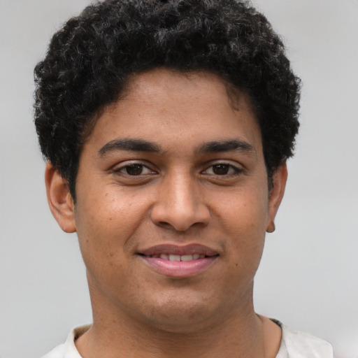 Joyful latino young-adult male with short  brown hair and brown eyes