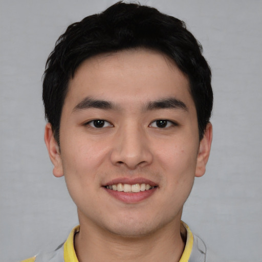 Joyful asian young-adult male with short  black hair and brown eyes