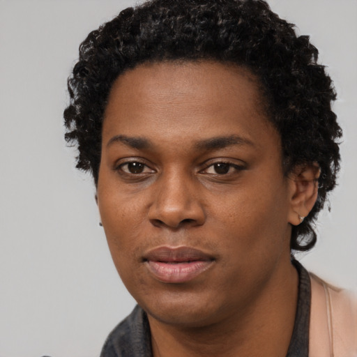 Joyful black young-adult female with short  black hair and brown eyes
