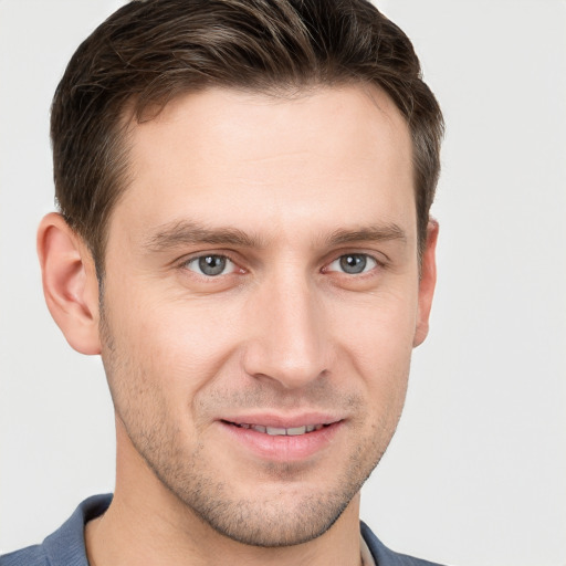 Joyful white young-adult male with short  brown hair and grey eyes