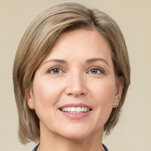 Joyful white young-adult female with medium  brown hair and grey eyes