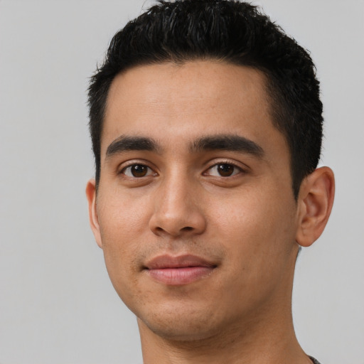 Joyful latino young-adult male with short  black hair and brown eyes