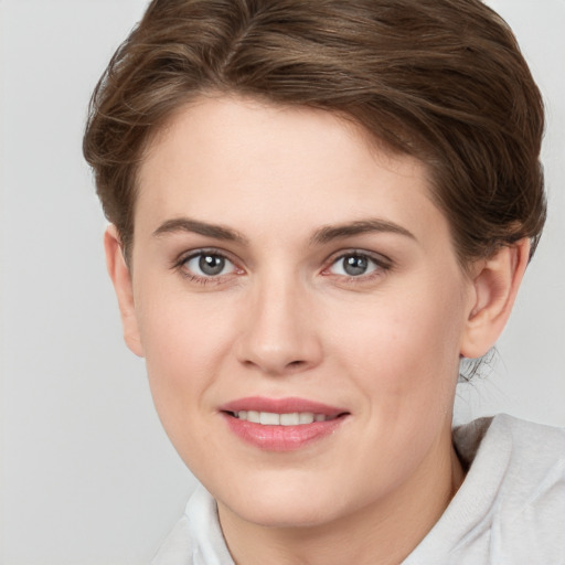 Joyful white young-adult female with short  brown hair and blue eyes