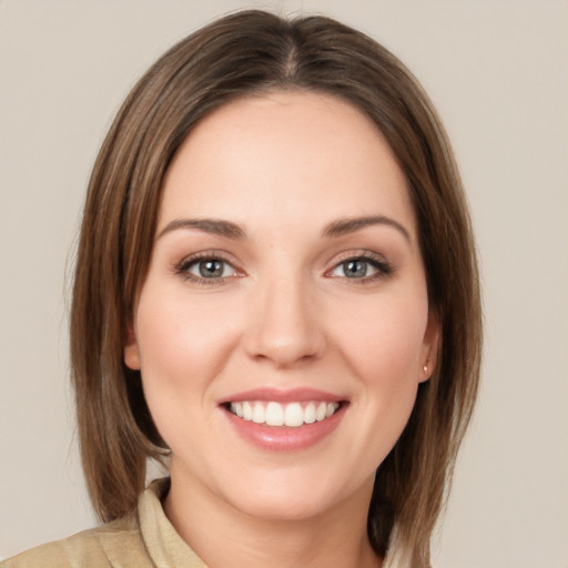 Joyful white young-adult female with medium  brown hair and green eyes