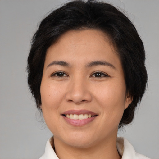 Joyful asian young-adult female with medium  brown hair and brown eyes