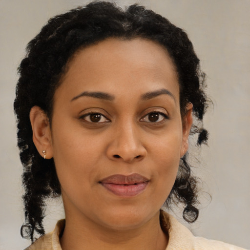 Joyful black young-adult female with medium  brown hair and brown eyes