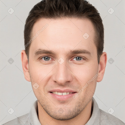 Joyful white young-adult male with short  brown hair and grey eyes