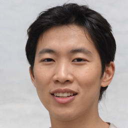 Joyful asian young-adult male with short  brown hair and brown eyes