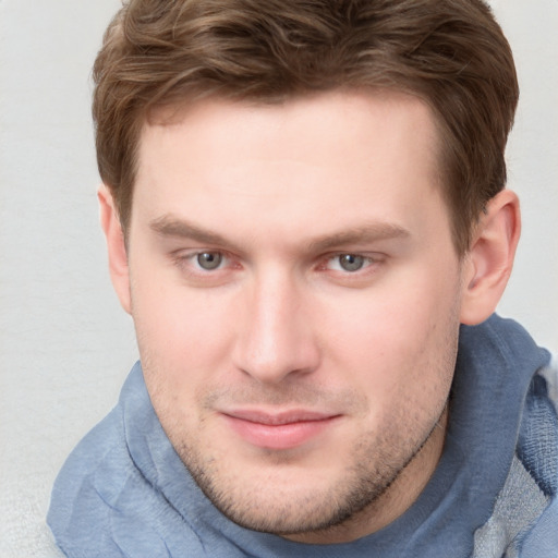 Joyful white young-adult male with short  brown hair and blue eyes