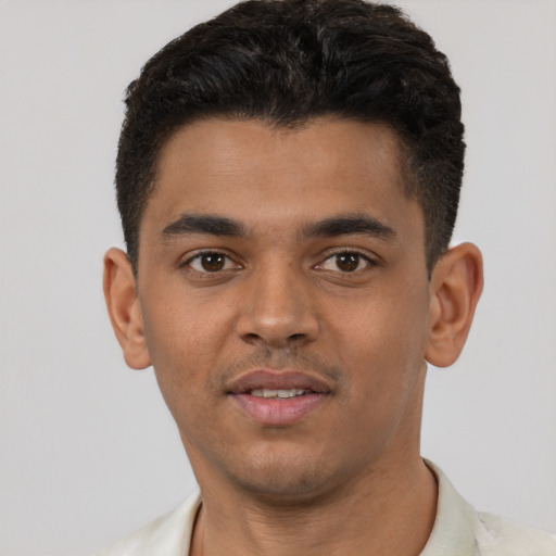 Joyful latino young-adult male with short  black hair and brown eyes