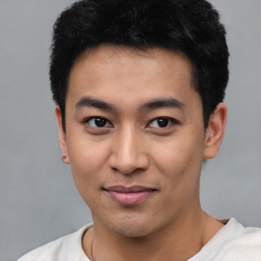 Joyful asian young-adult male with short  black hair and brown eyes