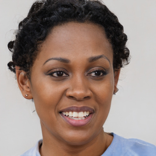 Joyful black young-adult female with short  black hair and brown eyes