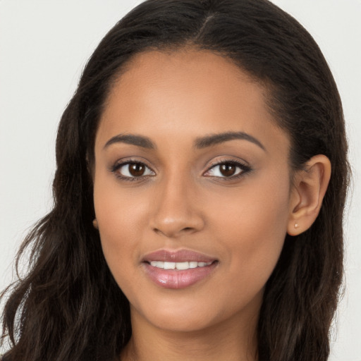 Joyful latino young-adult female with long  brown hair and brown eyes