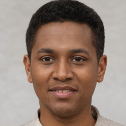 Joyful latino young-adult male with short  brown hair and brown eyes