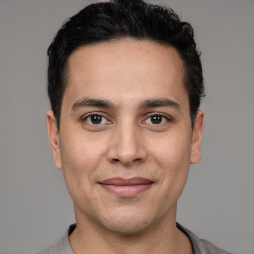 Joyful white young-adult male with short  black hair and brown eyes