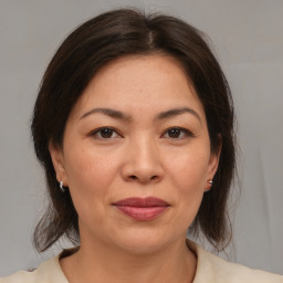 Joyful asian adult female with medium  brown hair and brown eyes