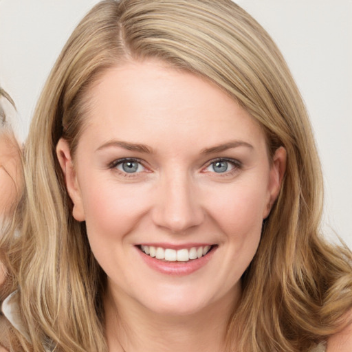 Joyful white young-adult female with long  brown hair and blue eyes