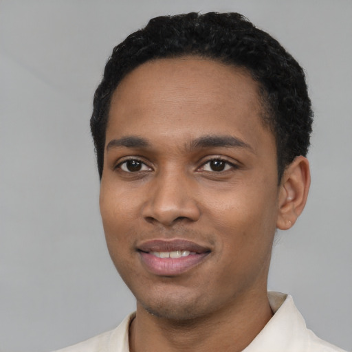 Joyful black young-adult male with short  black hair and brown eyes
