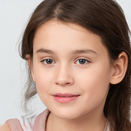 Joyful white child female with long  brown hair and brown eyes