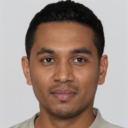 Joyful black young-adult male with short  black hair and brown eyes
