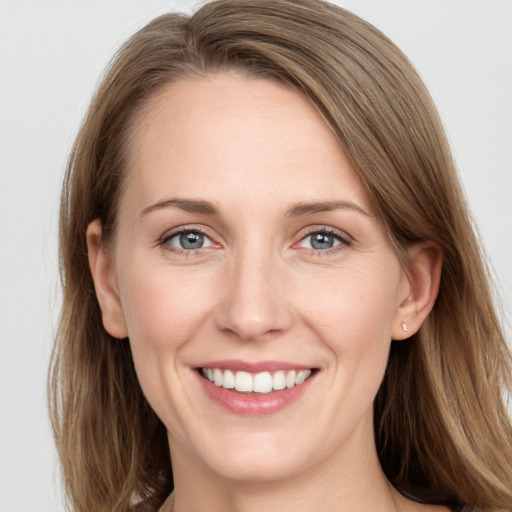 Joyful white young-adult female with long  brown hair and grey eyes