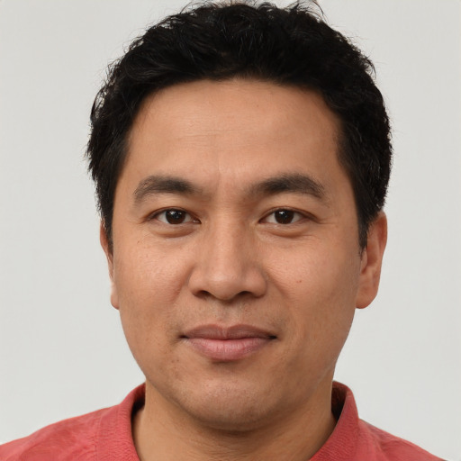 Joyful asian adult male with short  black hair and brown eyes
