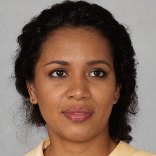 Joyful black adult female with medium  brown hair and brown eyes
