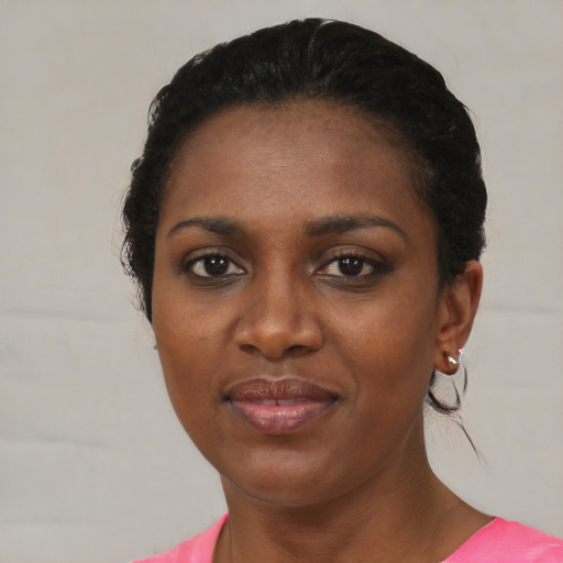 Joyful black young-adult female with short  black hair and brown eyes