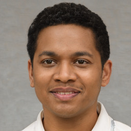 Joyful latino young-adult male with short  black hair and brown eyes