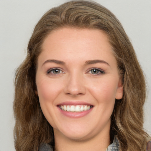 Joyful white young-adult female with long  brown hair and green eyes