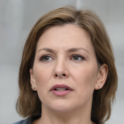 Joyful white adult female with medium  brown hair and grey eyes