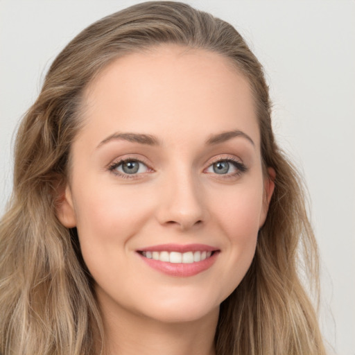 Joyful white young-adult female with long  brown hair and blue eyes