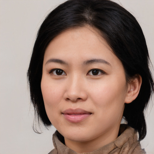 Joyful asian young-adult female with medium  black hair and brown eyes