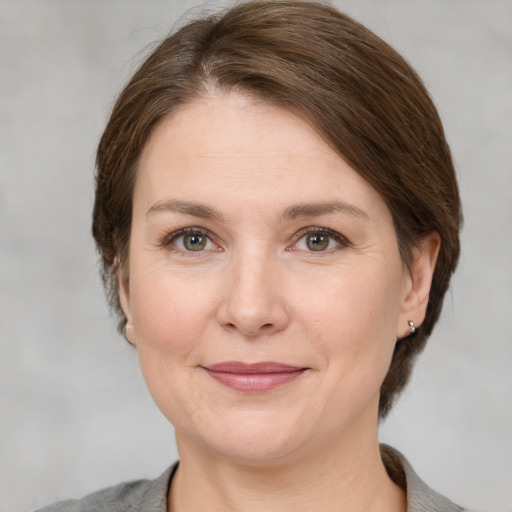 Joyful white adult female with medium  brown hair and grey eyes