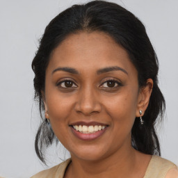 Joyful black young-adult female with medium  brown hair and brown eyes