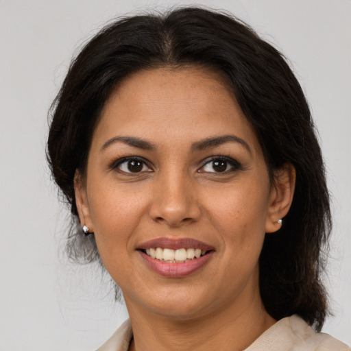 Joyful latino young-adult female with medium  brown hair and brown eyes