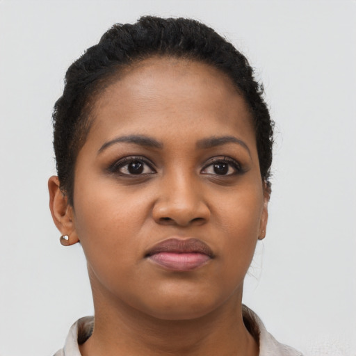 Joyful black young-adult female with short  brown hair and brown eyes