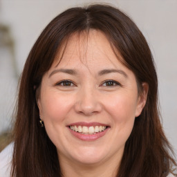 Joyful white adult female with long  brown hair and brown eyes