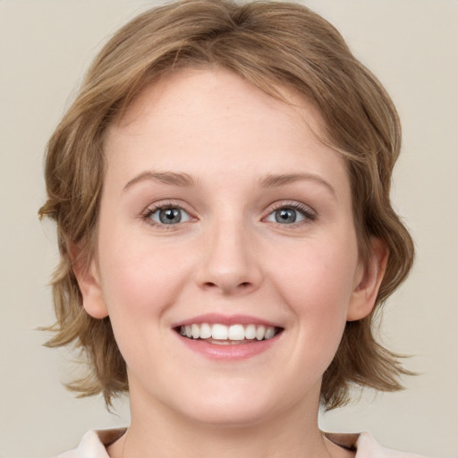 Joyful white young-adult female with medium  brown hair and blue eyes