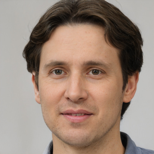 Joyful white adult male with short  brown hair and grey eyes