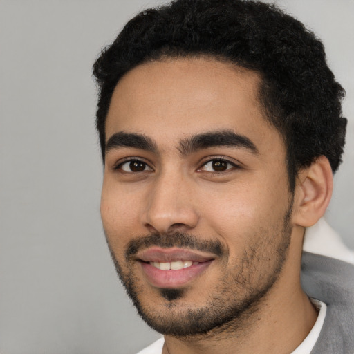 Joyful latino young-adult male with short  black hair and brown eyes