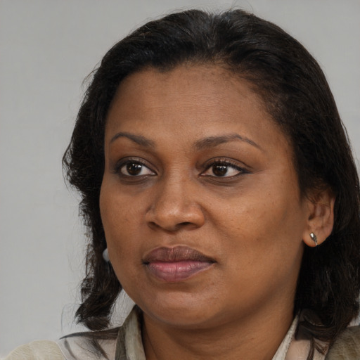 Joyful black adult female with medium  brown hair and brown eyes