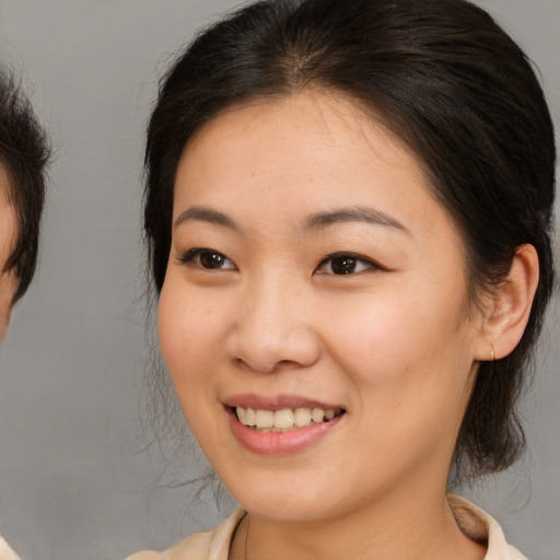Joyful asian young-adult female with medium  brown hair and brown eyes