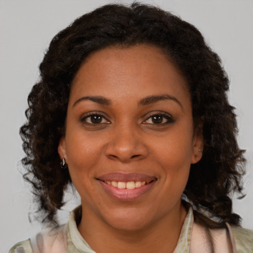 Joyful black young-adult female with medium  brown hair and brown eyes